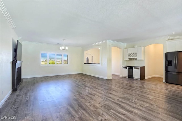 5500 Santovito St, Pahrump, NV 89061 - unfurnished living room with a fireplace, arched walkways, a chandelier, crown molding, and dark wood finished floors