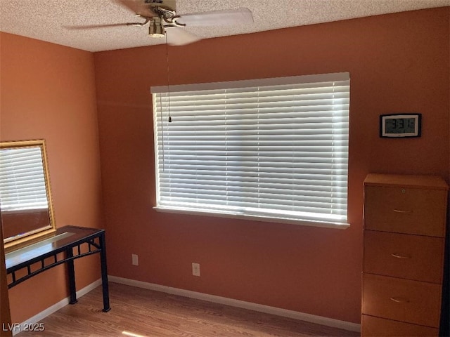 5821 Santa Catalina Ave, Las Vegas, NV 89108 - unfurnished bedroom with wood finished floors, a textured ceiling, multiple windows, and ceiling fan