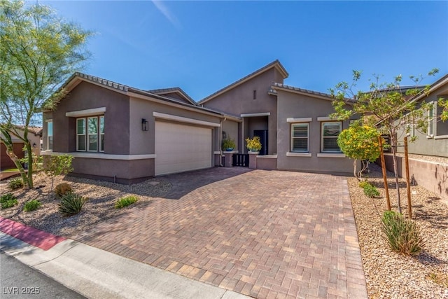 8 Via Tiberina, Las Vegas, NV 89011 - view of front of property with decorative driveway, an attached garage, and stucco siding