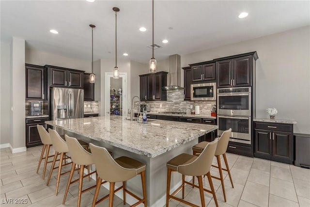 8 Via Tiberina, Las Vegas, NV 89011 - kitchen with stainless steel appliances, decorative backsplash, wall chimney exhaust hood, a spacious island, and a kitchen bar