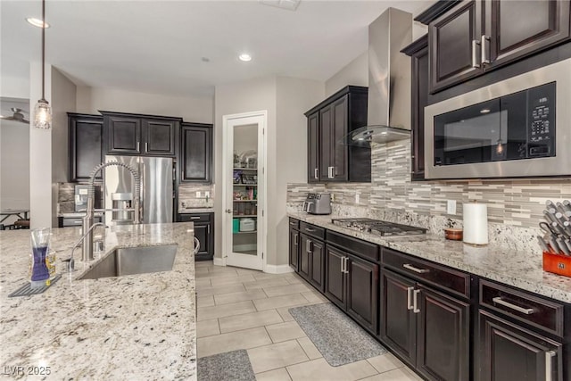 8 Via Tiberina, Las Vegas, NV 89011 - kitchen with wall chimney range hood, stainless steel appliances, decorative backsplash, light stone counters, and light tile patterned flooring