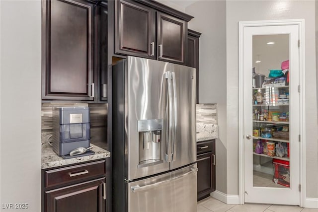 8 Via Tiberina, Las Vegas, NV 89011 - kitchen with stainless steel refrigerator with ice dispenser, dark brown cabinets, light stone countertops, light tile patterned floors, and decorative backsplash