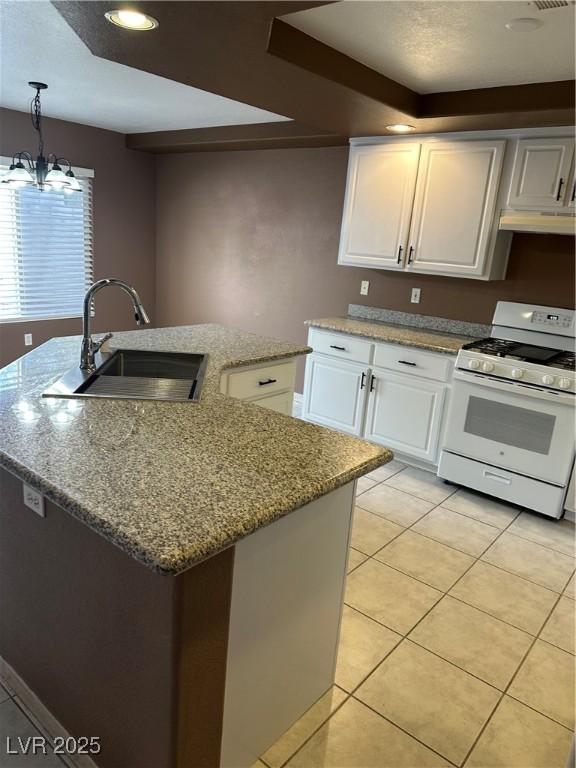 1511 Balsam Mist Ave, Las Vegas, NV 89183 - kitchen featuring white gas stove, a sink, light tile patterned floors, white cabinets, and light stone countertops