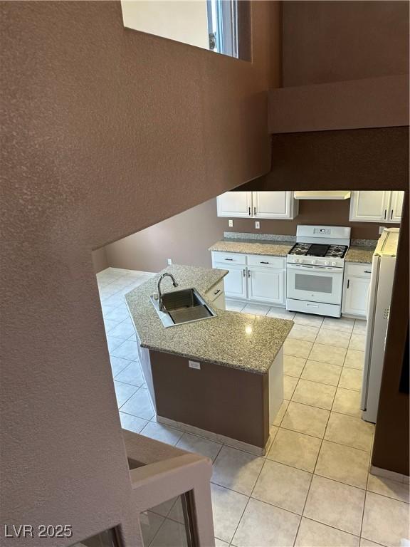 1511 Balsam Mist Ave, Las Vegas, NV 89183 - kitchen featuring white appliances, a sink, light tile patterned floors, white cabinets, and extractor fan