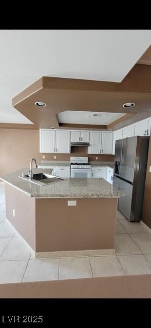 1511 Balsam Mist Ave, Las Vegas, NV 89183 - kitchen with stainless steel fridge, white range with gas cooktop, white cabinets, a peninsula, and light tile patterned floors
