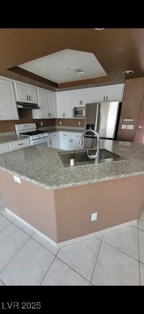 1511 Balsam Mist Ave, Las Vegas, NV 89183 - kitchen featuring white range with gas stovetop, stainless steel fridge, under cabinet range hood, and light tile patterned floors