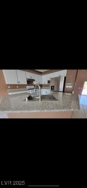 1511 Balsam Mist Ave, Las Vegas, NV 89183 - kitchen with a sink, stainless steel fridge, and white cabinets