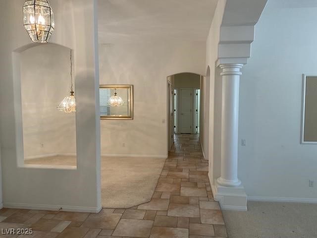 10816 Elm Ridge Ave, Las Vegas, NV 89144 - corridor featuring arched walkways, stone finish floors, ornate columns, baseboards, and carpet