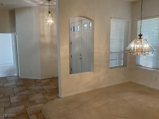 10816 Elm Ridge Ave, Las Vegas, NV 89144 - entrance foyer featuring a chandelier, arched walkways, baseboards, and stone finish flooring