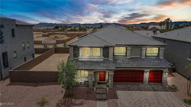 7255 Bold Rock Ave, Las Vegas, NV 89113 - french country home with stone siding, decorative driveway, a mountain view, and an attached garage