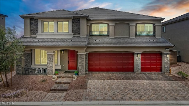 7255 Bold Rock Ave, Las Vegas, NV 89113 - view of front of property featuring stone siding, covered porch, decorative driveway, and stucco siding