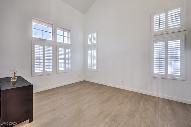 722 Descartes Ave, Henderson, NV 89002 - empty room featuring light wood-type flooring, plenty of natural light, baseboards, and high vaulted ceiling