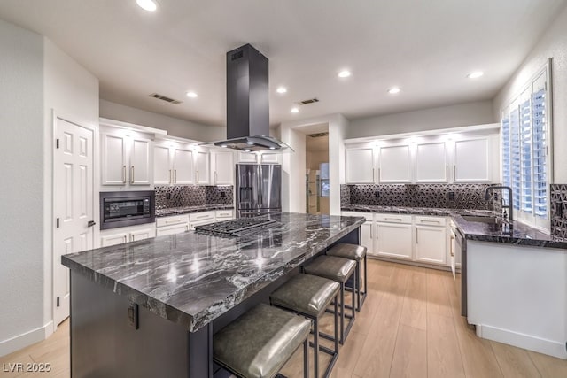 722 Descartes Ave, Henderson, NV 89002 - kitchen with stainless steel appliances, island range hood, a sink, white cabinetry, and backsplash
