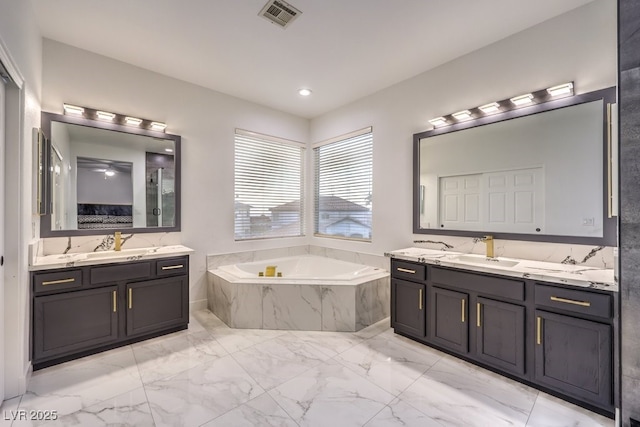 722 Descartes Ave, Henderson, NV 89002 - ensuite bathroom featuring marble look tile flooring, two vanities, and a bath