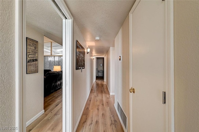 2496 Golfers St, Las Vegas, NV 89142 - hall featuring light wood-type flooring, a textured ceiling, and baseboards