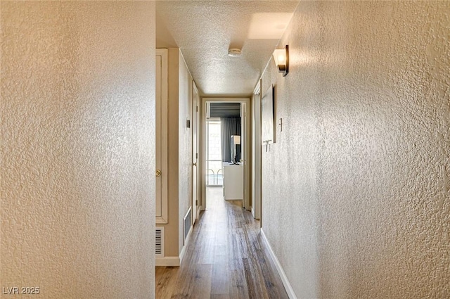 2496 Golfers St, Las Vegas, NV 89142 - corridor with wood finished floors, a textured ceiling, and baseboards