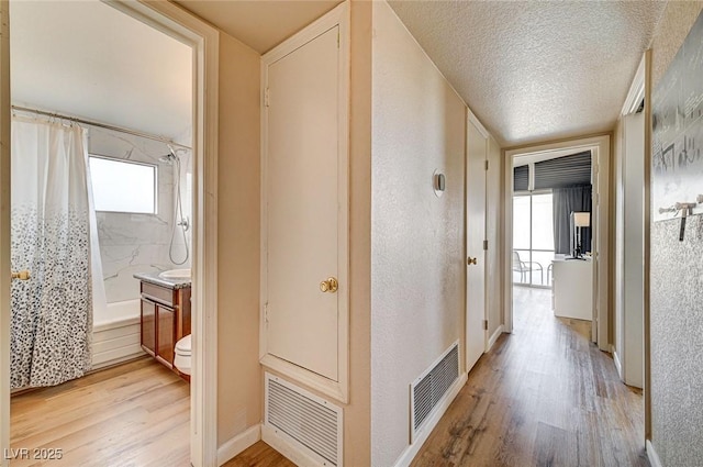 2496 Golfers St, Las Vegas, NV 89142 - hall featuring light wood-type flooring, a textured ceiling, and baseboards