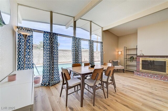 2496 Golfers St, Las Vegas, NV 89142 - dining area with light wood finished floors, beam ceiling, and a fireplace