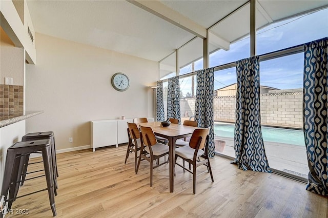 2496 Golfers St, Las Vegas, NV 89142 - dining room featuring healthy amount of natural light, light wood-type flooring, baseboards, and a wall of windows