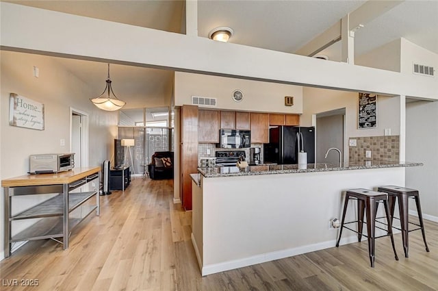 2496 Golfers St, Las Vegas, NV 89142 - kitchen with black appliances, decorative backsplash, light wood-type flooring, and high vaulted ceiling