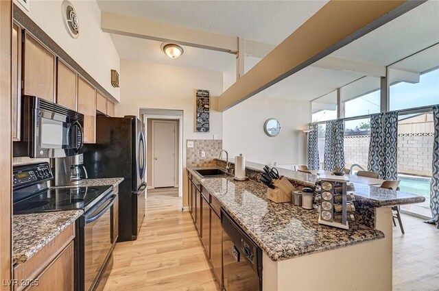 2496 Golfers St, Las Vegas, NV 89142 - kitchen with black appliances, a sink, a peninsula, and light wood-style floors
