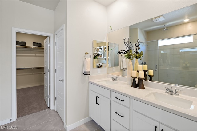 4130 E Brusca Way, Pahrump, NV 89061 - bathroom featuring a shower stall, double vanity, a spacious closet, tile patterned flooring, and baseboards