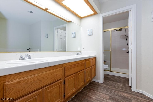 9817 Dardanelle Ct, Las Vegas, NV 89117 - full bathroom with double vanity, toilet, a stall shower, wood finished floors, and baseboards
