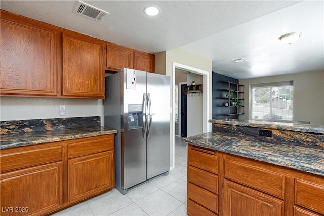 9817 Dardanelle Ct, Las Vegas, NV 89117 - kitchen with stainless steel refrigerator with ice dispenser, brown cabinets, light tile patterned floors, dark stone countertops, and recessed lighting