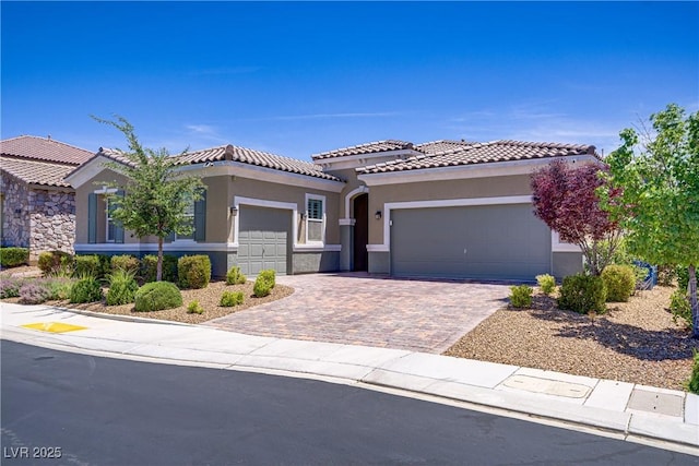 3155 Dalmazia Ave, Henderson, NV 89044 - mediterranean / spanish home featuring an attached garage, stucco siding, a tiled roof, and driveway
