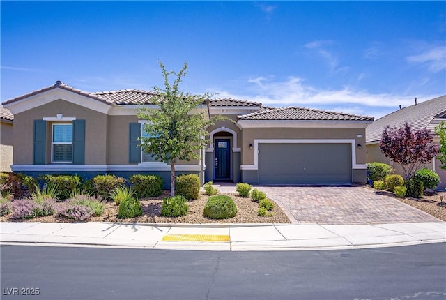 3155 Dalmazia Ave, Henderson, NV 89044 - mediterranean / spanish house featuring a garage, a tiled roof, stucco siding, and driveway