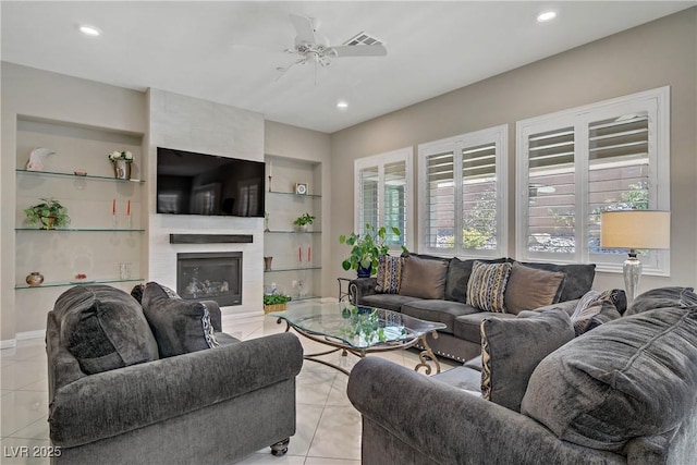 3155 Dalmazia Ave, Henderson, NV 89044 - living room with light tile patterned floors, a large fireplace, built in shelves, a ceiling fan, and recessed lighting