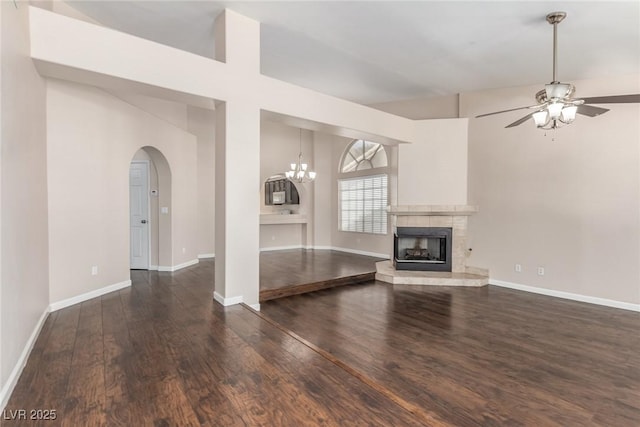 9305 Hollycrest Dr, Las Vegas, NV 89117 - unfurnished living room with wood finished floors, a fireplace, a ceiling fan, a chandelier, and arched walkways