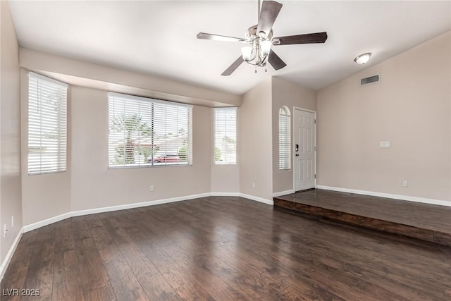 9305 Hollycrest Dr, Las Vegas, NV 89117 - spare room featuring dark wood-type flooring, vaulted ceiling, a ceiling fan, and baseboards