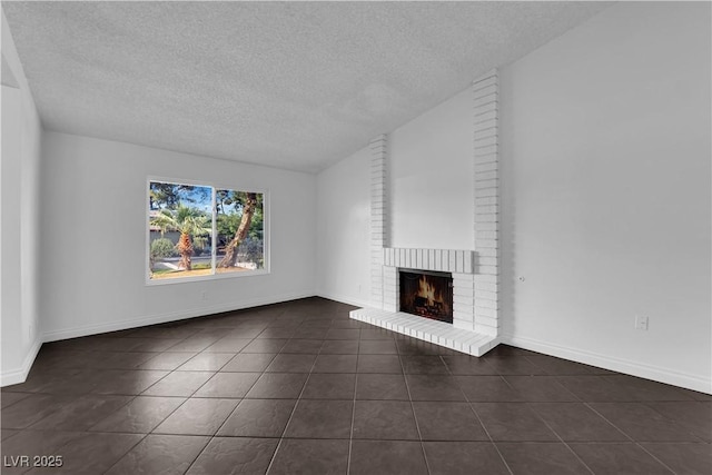 6791 Greengrove Dr, Las Vegas, NV 89103 - unfurnished living room with dark tile patterned flooring, a textured ceiling, a fireplace, and baseboards