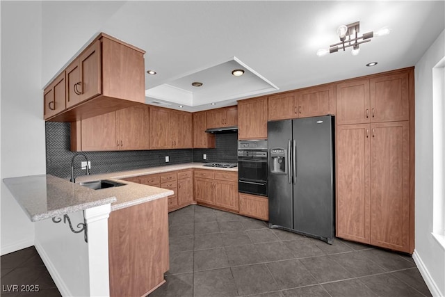 6791 Greengrove Dr, Las Vegas, NV 89103 - kitchen featuring black appliances, a peninsula, backsplash, a sink, and a tray ceiling