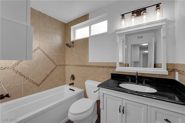 6791 Greengrove Dr, Las Vegas, NV 89103 - bathroom featuring toilet, vanity, shower / washtub combination, and tile walls