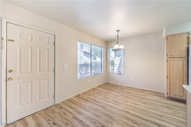 5710 E Tropicana Ave Unit 1114, Las Vegas, NV 89122 - unfurnished dining area featuring light wood-style floors, baseboards, and a chandelier