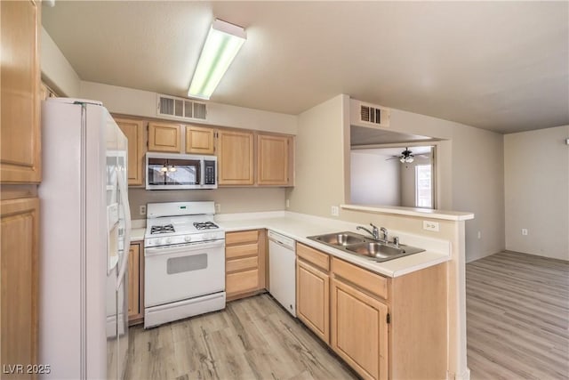 5710 E Tropicana Ave Unit 1114, Las Vegas, NV 89122 - kitchen featuring white appliances, light brown cabinets, a sink, light wood-style flooring, and a peninsula