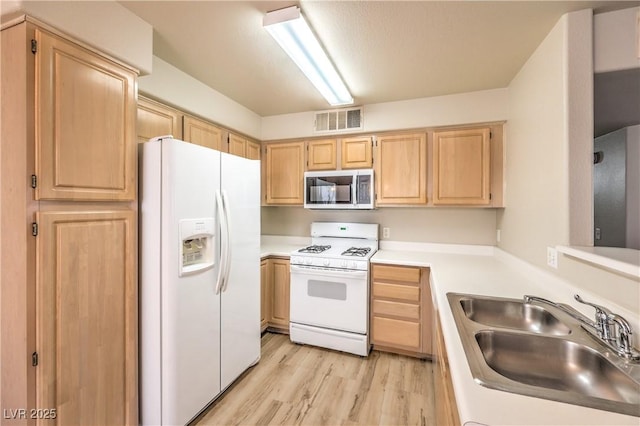 5710 E Tropicana Ave Unit 1114, Las Vegas, NV 89122 - kitchen with white appliances, light brown cabinets, a sink, and light wood-type flooring