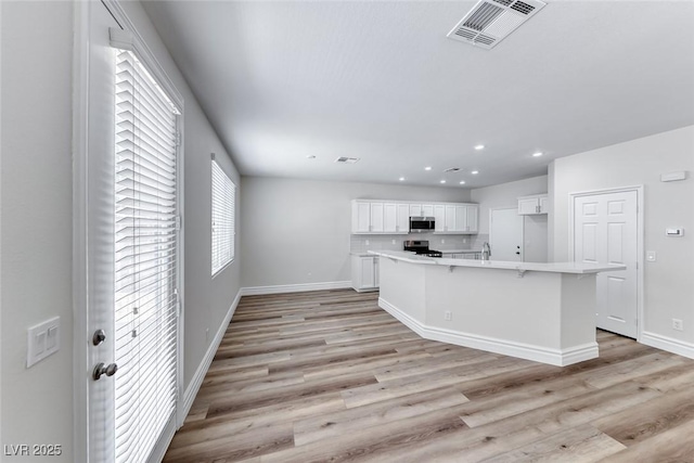 9766 Marcelline Ave, Las Vegas, NV 89148 - kitchen featuring stainless steel appliances, white cabinetry, recessed lighting, light countertops, and light wood-style flooring