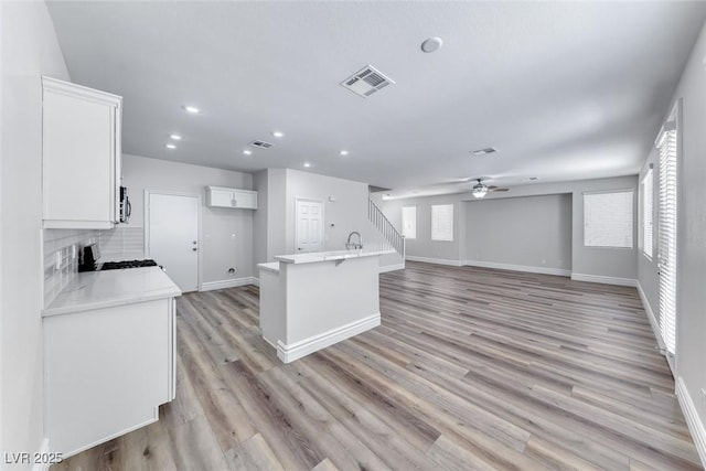 9766 Marcelline Ave, Las Vegas, NV 89148 - kitchen featuring range with gas stovetop, white cabinetry, ceiling fan, baseboards, and tasteful backsplash