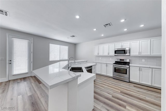 9766 Marcelline Ave, Las Vegas, NV 89148 - kitchen with appliances with stainless steel finishes, a sink, tasteful backsplash, recessed lighting, and an island with sink