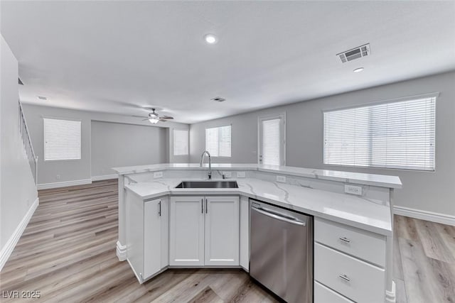 9766 Marcelline Ave, Las Vegas, NV 89148 - kitchen with stainless steel dishwasher, a sink, a ceiling fan, light wood finished floors, and light stone countertops