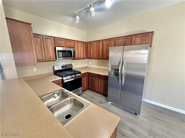 10455 Alpine Edge Ave, Las Vegas, NV 89129 - kitchen with stainless steel appliances, a sink, light wood-style flooring, and light countertops