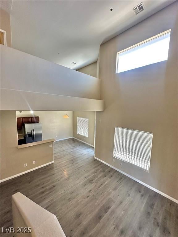 10455 Alpine Edge Ave, Las Vegas, NV 89129 - unfurnished living room featuring wood finished floors, baseboards, and lofted ceiling