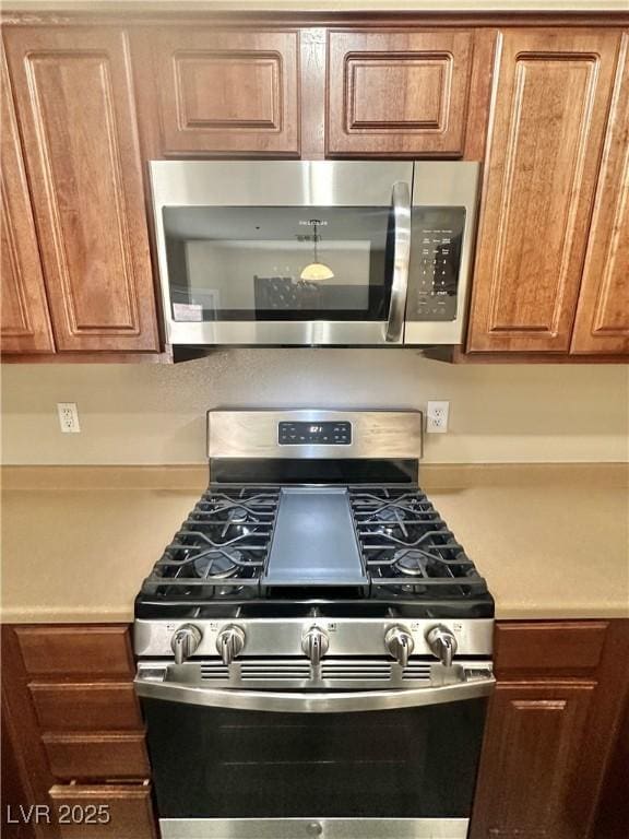 10455 Alpine Edge Ave, Las Vegas, NV 89129 - kitchen featuring stainless steel appliances, light countertops, and brown cabinetry