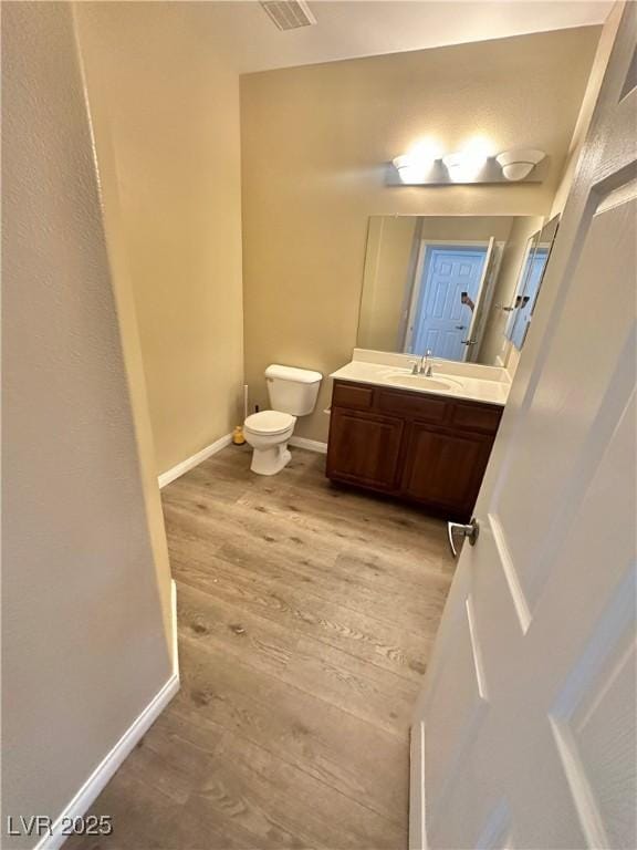 10455 Alpine Edge Ave, Las Vegas, NV 89129 - half bath featuring wood finished floors, toilet, vanity, and baseboards