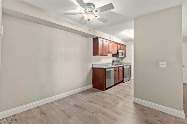 2606 S Durango Dr Unit 245, Las Vegas, NV 89117 - kitchen featuring appliances with stainless steel finishes, baseboards, a ceiling fan, and light wood-style flooring