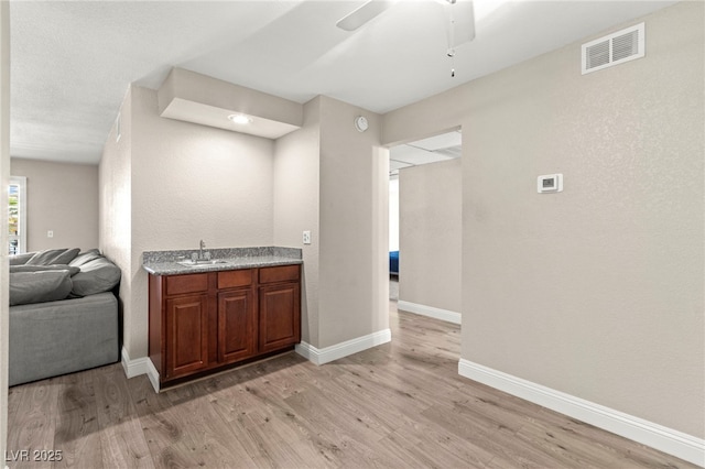 2606 S Durango Dr Unit 245, Las Vegas, NV 89117 - bar featuring light wood finished floors, baseboards, a sink, and a ceiling fan
