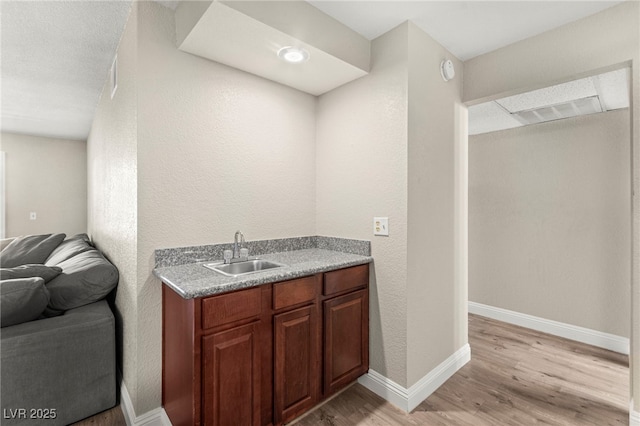 2606 S Durango Dr Unit 245, Las Vegas, NV 89117 - bar featuring a sink, light wood-style flooring, and baseboards